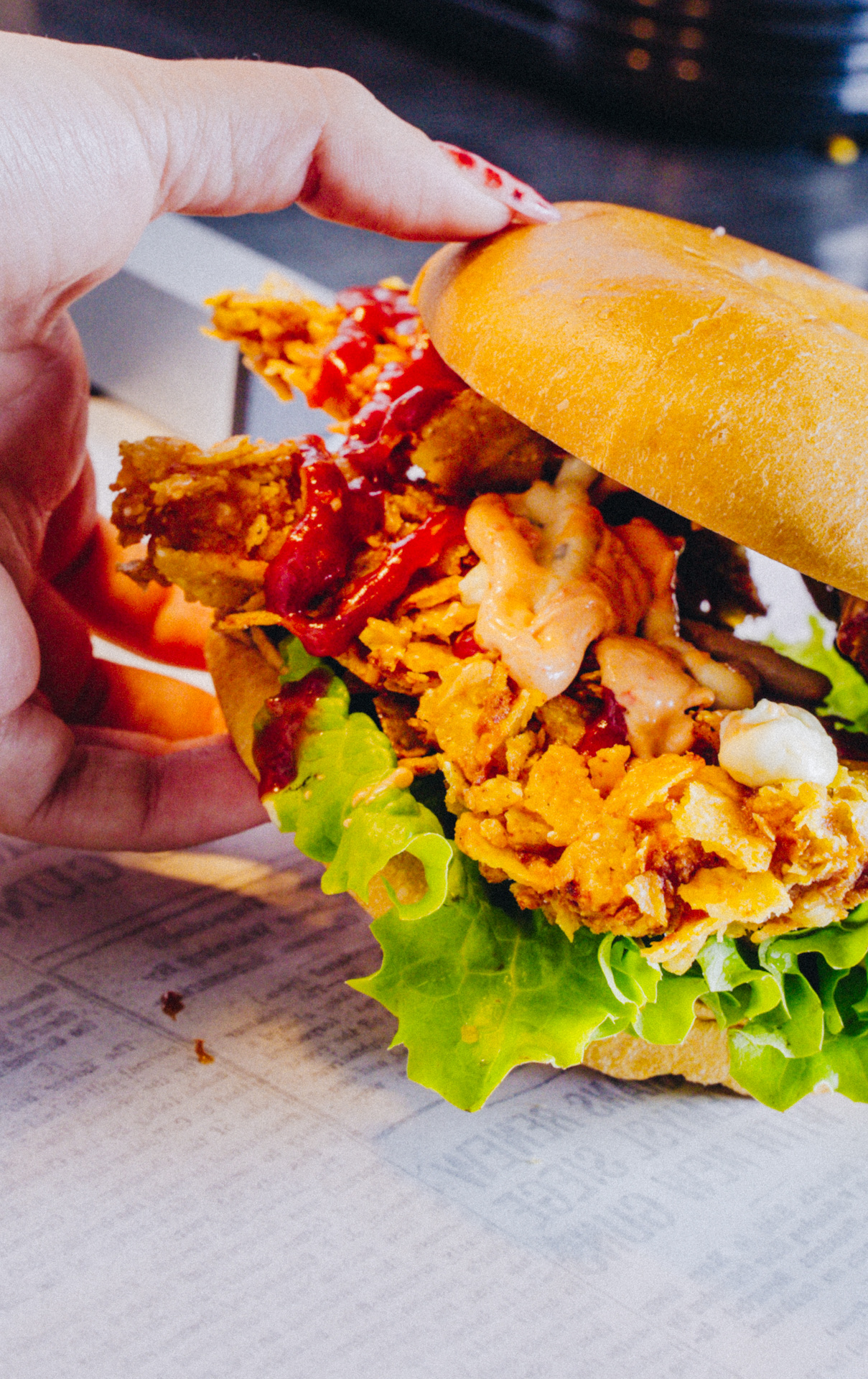 A Dirty F*cking Burgers chicken sandwich with crispy cornflake chicken, lettuce and sauces